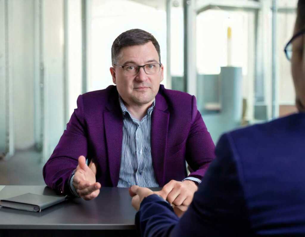 Photo Of A Middle Aged Man Wearing A Dark Purple Jacket In An Office Setting Inter